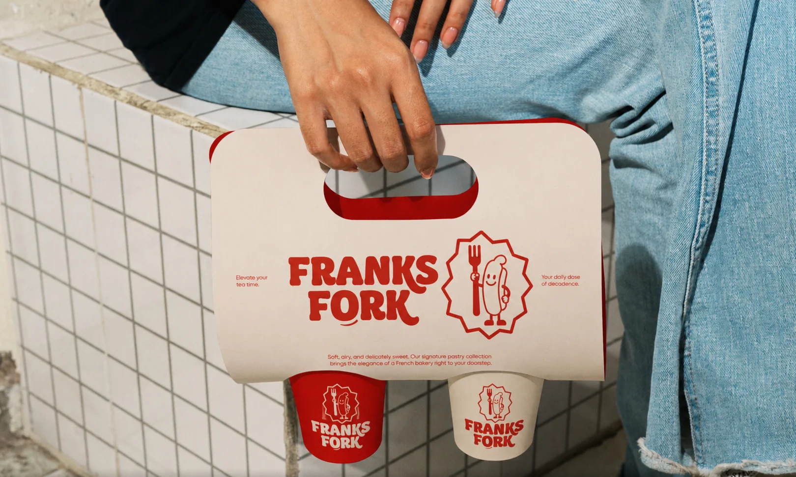 Franks Fork two-cup takeaway drink carrier in cream and red, carried on the street