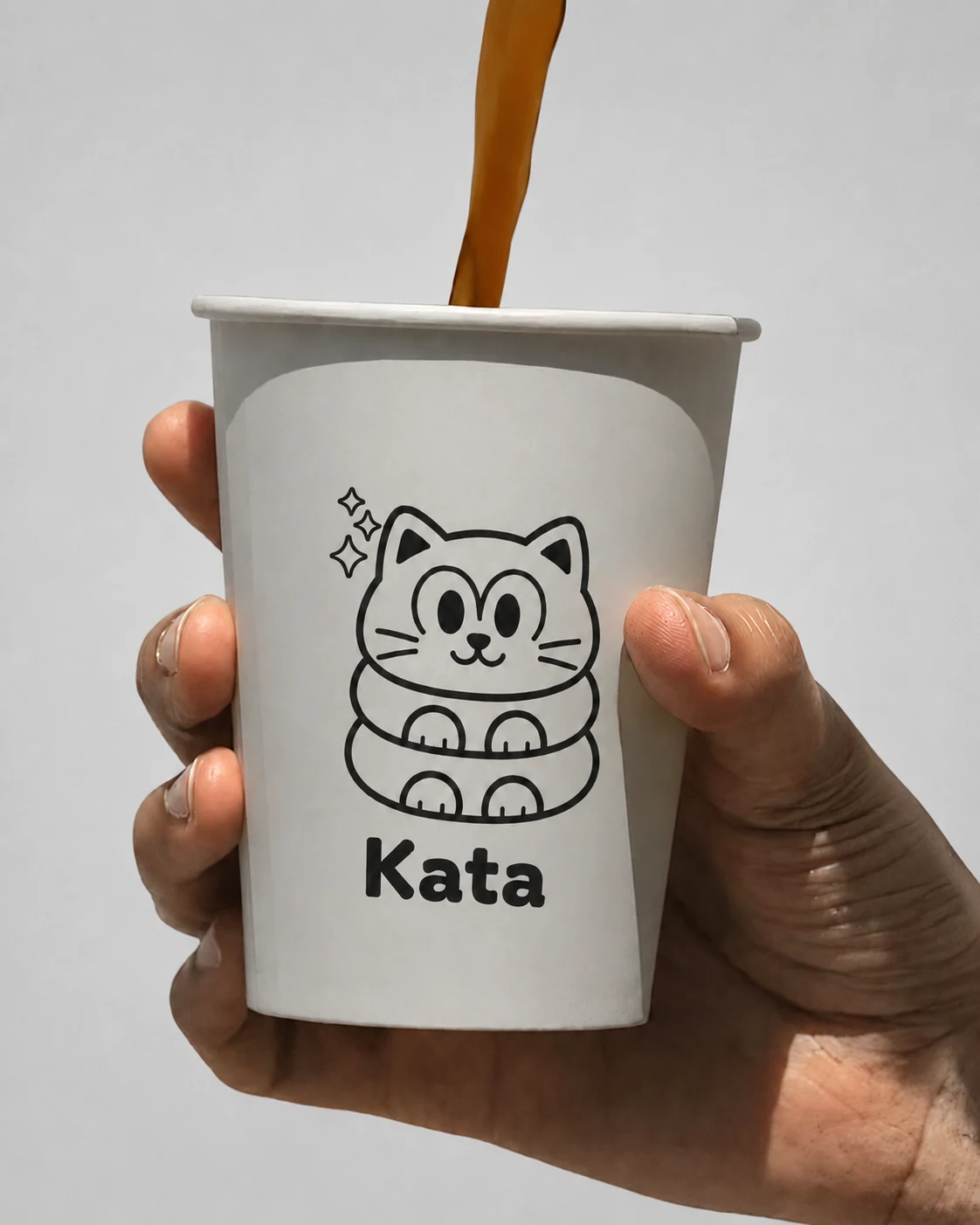 A Kata Cat coffee cup held in hand as coffee is poured
